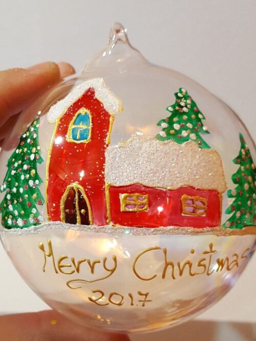Pallina di Natale in vetro trasparente decorata con casetta innevata