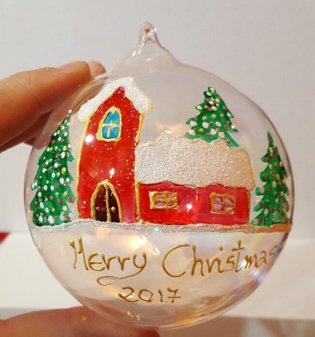 Pallina di Natale in vetro trasparente decorata con casetta innevata